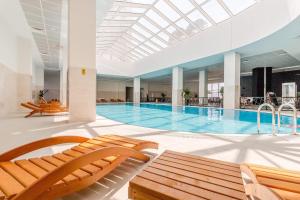 einen großen Pool mit zwei Stühlen und einem Pool in der Unterkunft 33rd floor luxury apartment spa & fitness in Skopje