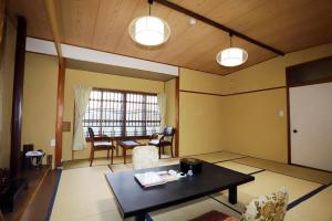 a living room with a table and a dining room at Hinode Ryokan in Ise