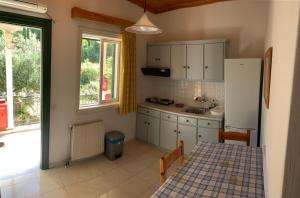 a small kitchen with a table and a refrigerator at Filoxenia Kontogiannis in Lazaráta