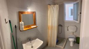 a bathroom with a sink and a toilet and a mirror at Filoxenia Kontogiannis in Lazaráta