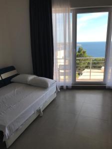 ein Schlafzimmer mit einem Bett und einem großen Fenster in der Unterkunft Villa Grand in Bar + 99 Fotos