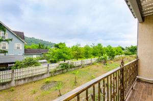 a balcony with a fence and a yard at 梅花湖-陽光屋民宿 in Dongshan