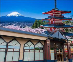 a building with a pagoda and a mountain in the background at Mt.Fuji Cabin & Lounge Highland Station Inn (Capsule Hotel) in Fujikawaguchiko