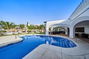 a swimming pool in front of a house at Hotel Bajamar Ancladero Playa in Nerja
