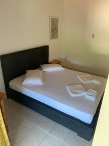 a bed with white sheets and pillows in a room at Filoxenia Kontogiannis in Lazaráta