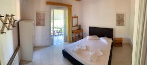 a bedroom with a white bed and a refrigerator at Filoxenia Kontogiannis in Lazaráta