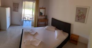 a bedroom with a white bed with pillows on it at Filoxenia Kontogiannis in Lazaráta