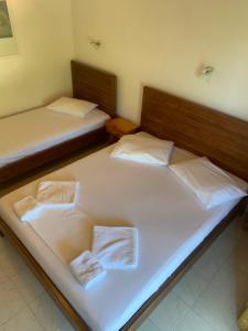 two beds in a room with white sheets at Filoxenia Kontogiannis in Lazaráta