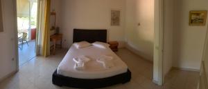 a bedroom with a bed with white sheets and pillows at Filoxenia Kontogiannis in Lazaráta