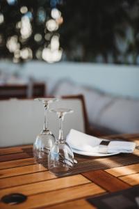 a pair of wine glasses sitting on a table at Hotel St.John Suites Adults Only in Tsilivi