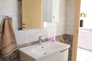 bagno con lavandino e specchio di Mihalis Apartments a Himare