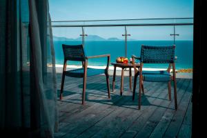two chairs and a table on a balcony with the ocean at Duyen Ha Resort Cam Ranh in Cam Ranh