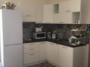 a kitchen with white cabinets and a white refrigerator at La terrazza sul Duomo B&B in Salerno