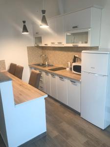 eine Küche mit weißen Schränken und einem weißen Kühlschrank in der Unterkunft Villa Grand in Bar