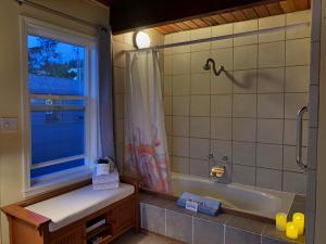 Wheeler的住宿－Wheeler on the Bay Lodge and Marina，带浴缸、水槽和窗户的浴室
