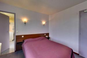 1 dormitorio con cama rosa y espejo en Logis Auberge des Vieux Chenes, en Malemort-sur-Corrèze