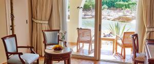 a living room with a table and chairs and a window at Kempinski Hotel Soma Bay in Hurghada