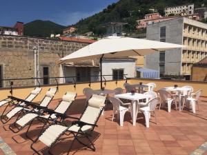 a patio with tables and chairs and an umbrella at La terrazza sul Duomo B&B in Salerno