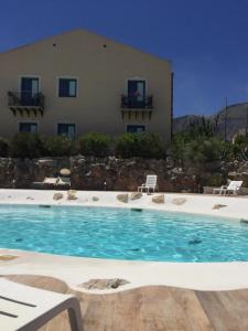 a large swimming pool in front of a building at Baglio Dello Zingaro in Scopello
