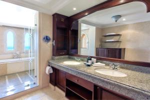 a bathroom with two sinks and a large mirror at Kempinski Hotel Soma Bay in Hurghada