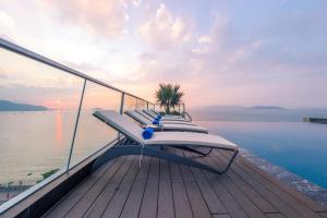 a row of lounge chairs sitting on the deck of a yacht at Boton Blue Hotel & Spa in Nha Trang