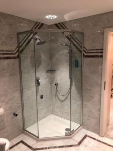 um chuveiro com uma caixa de vidro na casa de banho em 3 Apartments Am Wambolter Hof 3 em Bensheim