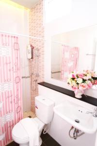 ein Badezimmer mit einem WC, einem Waschbecken und einem Spiegel in der Unterkunft บ้านธนาบูติคโฮเทล in Surat Thani