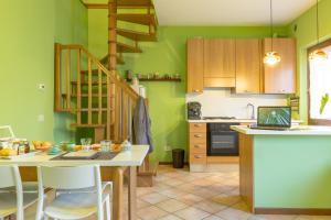 una cocina con paredes verdes y una escalera de caracol en Ca' dei Gatti, en Toscolano Maderno