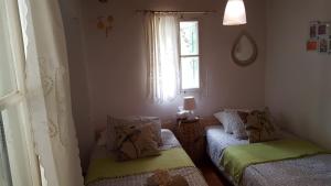 a small room with two beds and a window at Chios Stone House in Chios