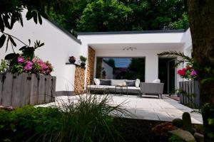 a patio with a couch in a yard at Leverkusen Schlebusch Ferienhaus in Leverkusen