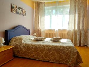Un dormitorio con una cama con dos almohadas encima. en Apartamentai 76, en Druskininkai