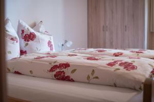 a bed with red flowers on it in a room at Bauernhof Farnach in Andelsbuch