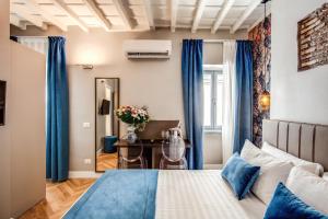 羅馬的住宿－Maison d'Art Apartments - Maison d'Art Collection，一间卧室配有一张带蓝色窗帘的床和一张桌子