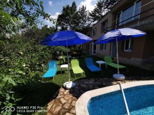 two blue umbrellas and chairs next to a pool at Villa Aqua in Pravets