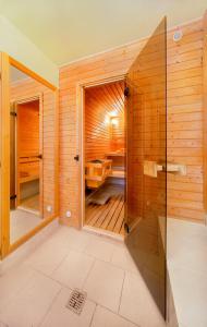 uma sauna com uma porta de vidro numa casa de banho em madeira em Lucni Dum em Janske Lazne