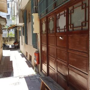 an alley with a wooden garage door and a bench at San Bu strolling in Tainan