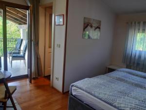 a bedroom with a bed and a table and a balcony at Rooms Leban in Šempas +30 photos