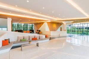 vestíbulo con sofá largo y almohadas de color naranja en J Inspired Hotel Pattaya - SHA Extra Plus, en Pattaya central