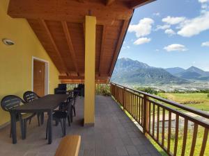 einen Balkon mit einem Tisch, Stühlen und Bergen in der Unterkunft B&B Tomaselli in Striegen