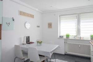 a white kitchen with a table and chairs at DeuxPonts Ferienwohnung in Zweibrücken +20 photos
