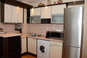 una cocina con nevera y lavadora en Апартамент София, en Golden Sands