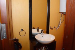 un baño con lavabo y espejo en Апартамент София, en Golden Sands 9 fotos más