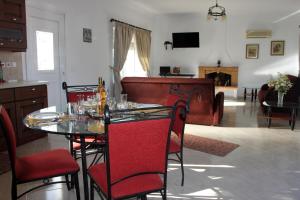 ein Esszimmer mit einem Tisch und Stühlen sowie ein Wohnzimmer in der Unterkunft Evans Villa in Arkasa