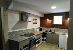a kitchen with granite counter tops and a window at Apartament Forn d'ITA in Esterri d'Àneu