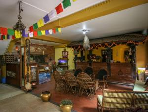 sala de estar con mesa, sillas y chimenea en Golden Gate Guest House, en Bhaktapur