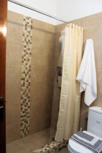 a bathroom with a shower with a toilet and a shower curtain at Evans Villa 2 in Arkasa