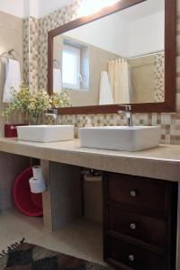 a bathroom with two sinks and a large mirror at Evans Villa 2 in Arkasa