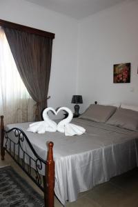 a bed with two swans in the shape of a heart at Evans Villa 2 in Arkasa