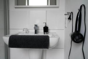 a bathroom sink with a black towel on it at Hostel Nordkirchen by Frerichmann in Nordkirchen