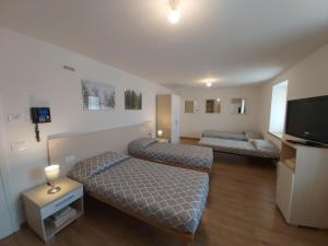 ein Zimmer mit zwei Betten und einem Flachbildfernseher in der Unterkunft B&B Tomaselli in Striegen